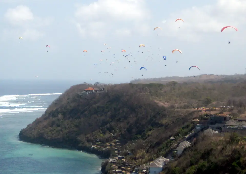 Dozens of paragliders soaring above the sea cliffs at Timbis on Bali's Bukit Peninsula