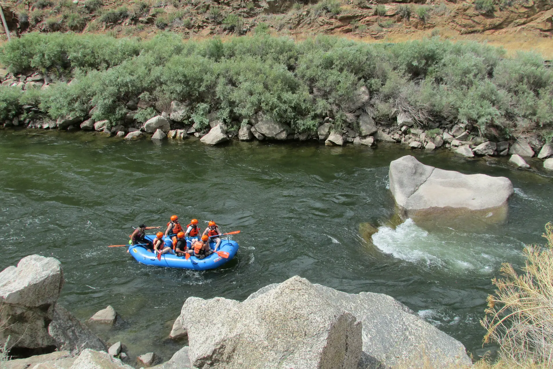 Eine Raft-Crew paddelt durch eine Stromschnelle des Arkansas River im Bighorn Sheep Canyon bei Cañon City
