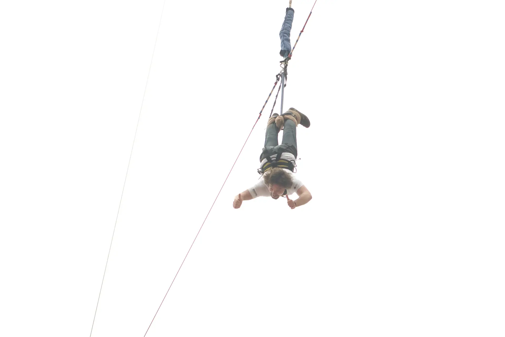 Ein Bungee-Springer im freien Fall kopfüber von einer Turmplattform, das Seil hinter ihm (Symbolbild, Macau Tower, nicht Poroy)