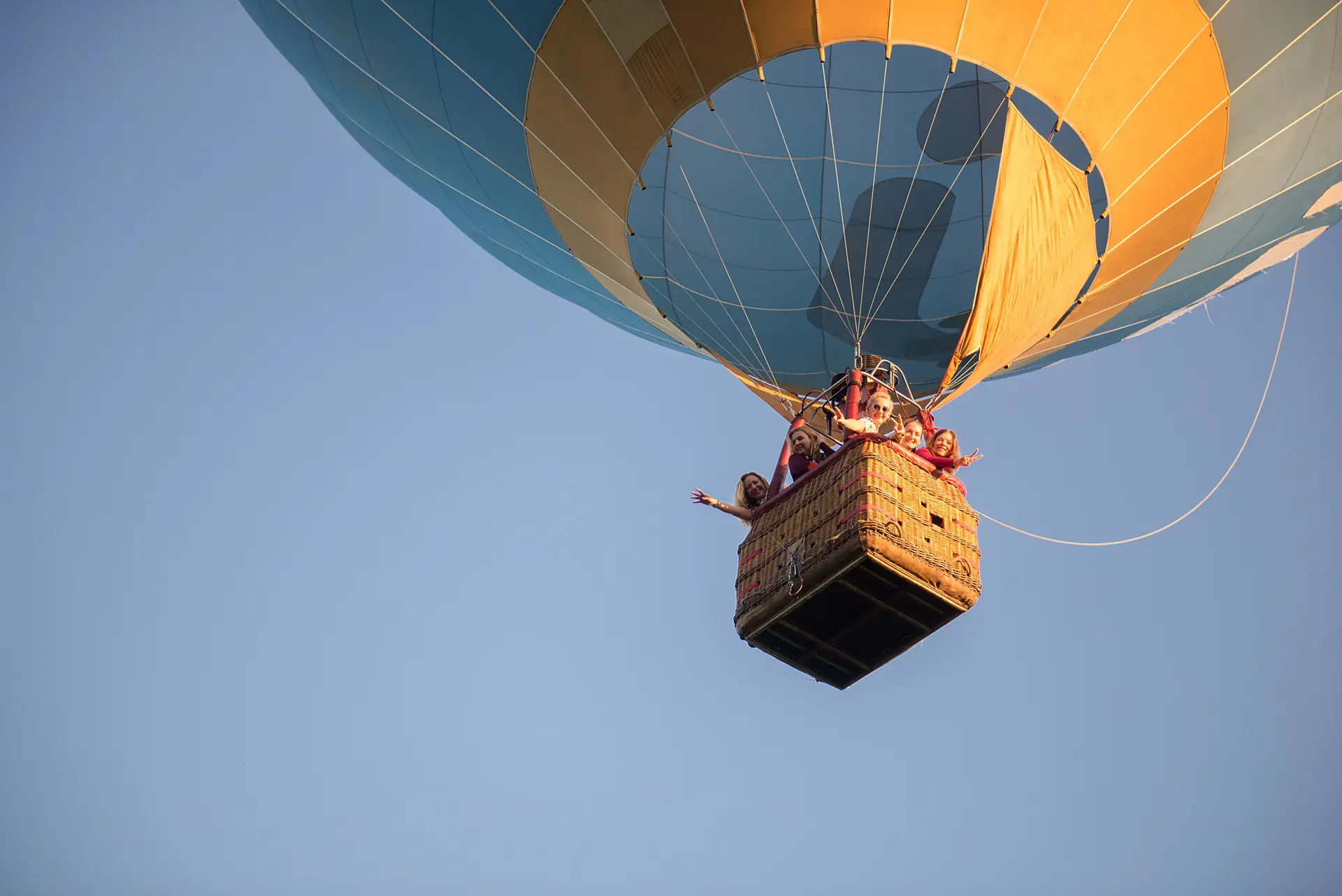 Ein Heißluftballon mit Passagieren im Korb vor klarem Himmel (Symbolbild, nicht Championsgate)
