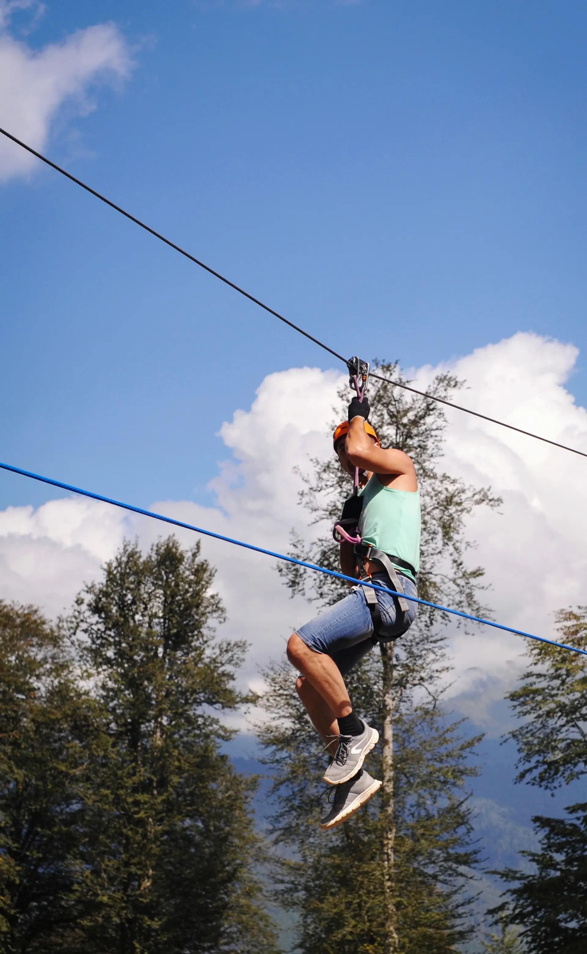 Ein Fahrer hängt an der Zipline vor blauem Himmel und Baumwipfeln (Symbolbild, nicht Ocala)