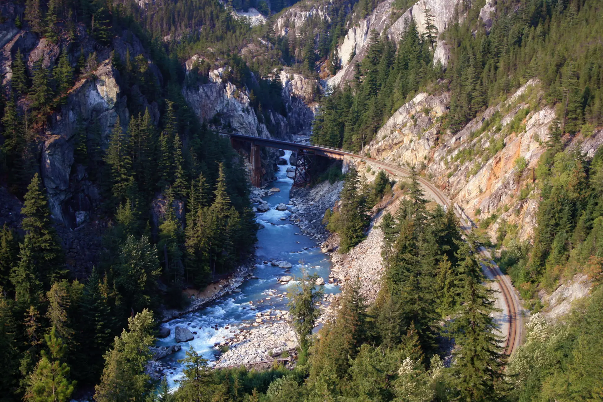 The Cheakamus River running through its rocky canyon beneath a railway bridge