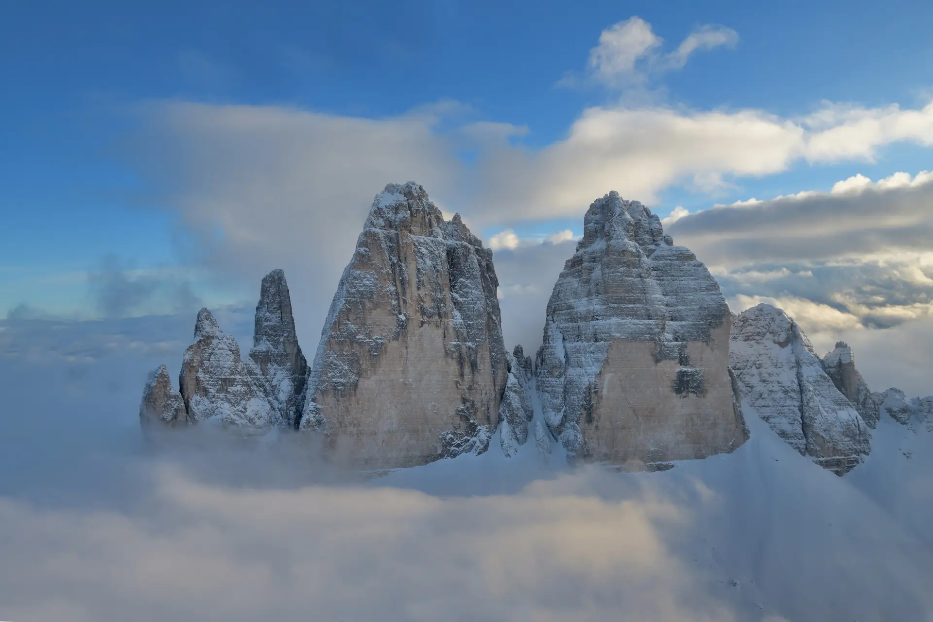 Die drei Felstürme der Drei Zinnen in den Dolomiten unter einem bewölkten Himmel