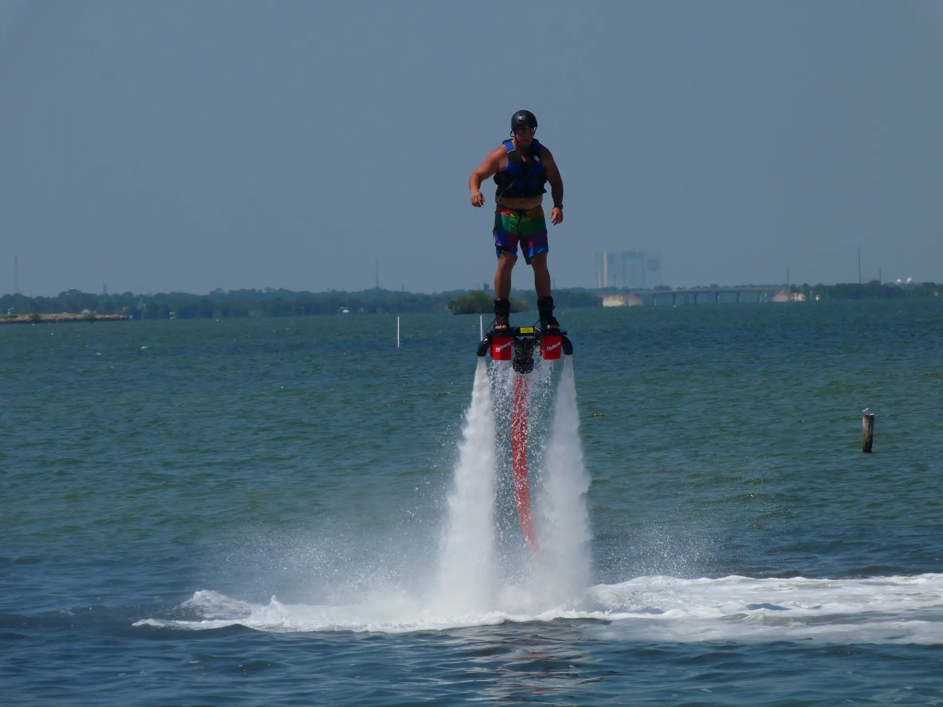 A flyboarder standing on two jets of water above a Florida lagoon