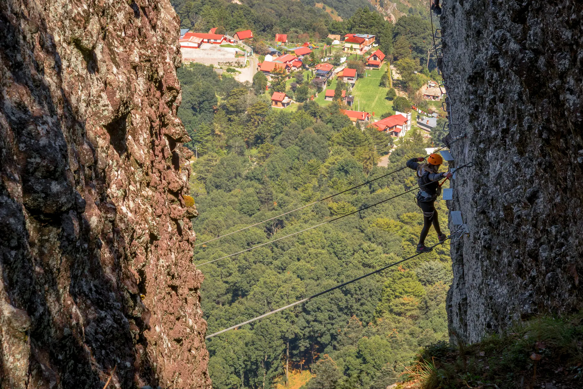 A climber clipped to a via ferrata cable on a cliff above the sea (symbolic image, not Gran Canaria)