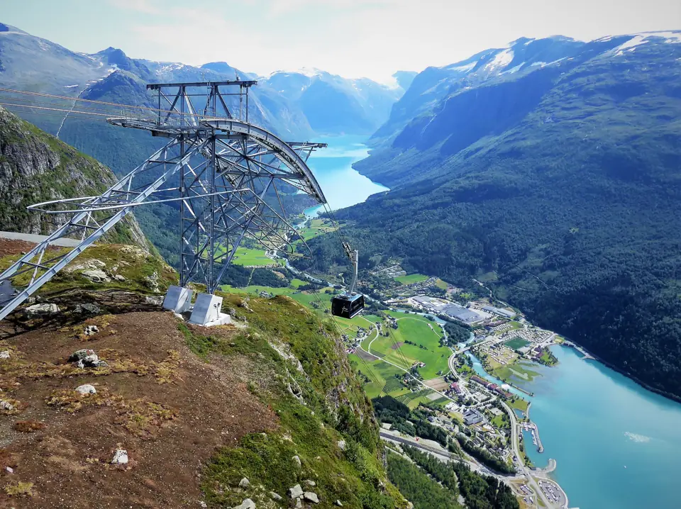 A Loen Skylift cabin hanging from the cable high above the Nordfjord, the fjord and green valley floor far below