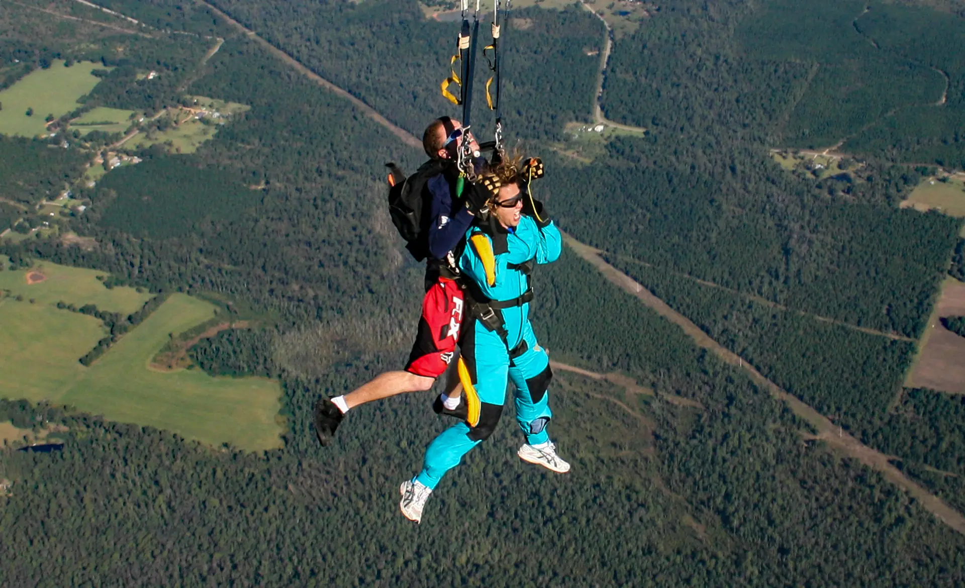 A tandem pair under an open canopy high above a forest (symbolic image, not Playa del Carmen)