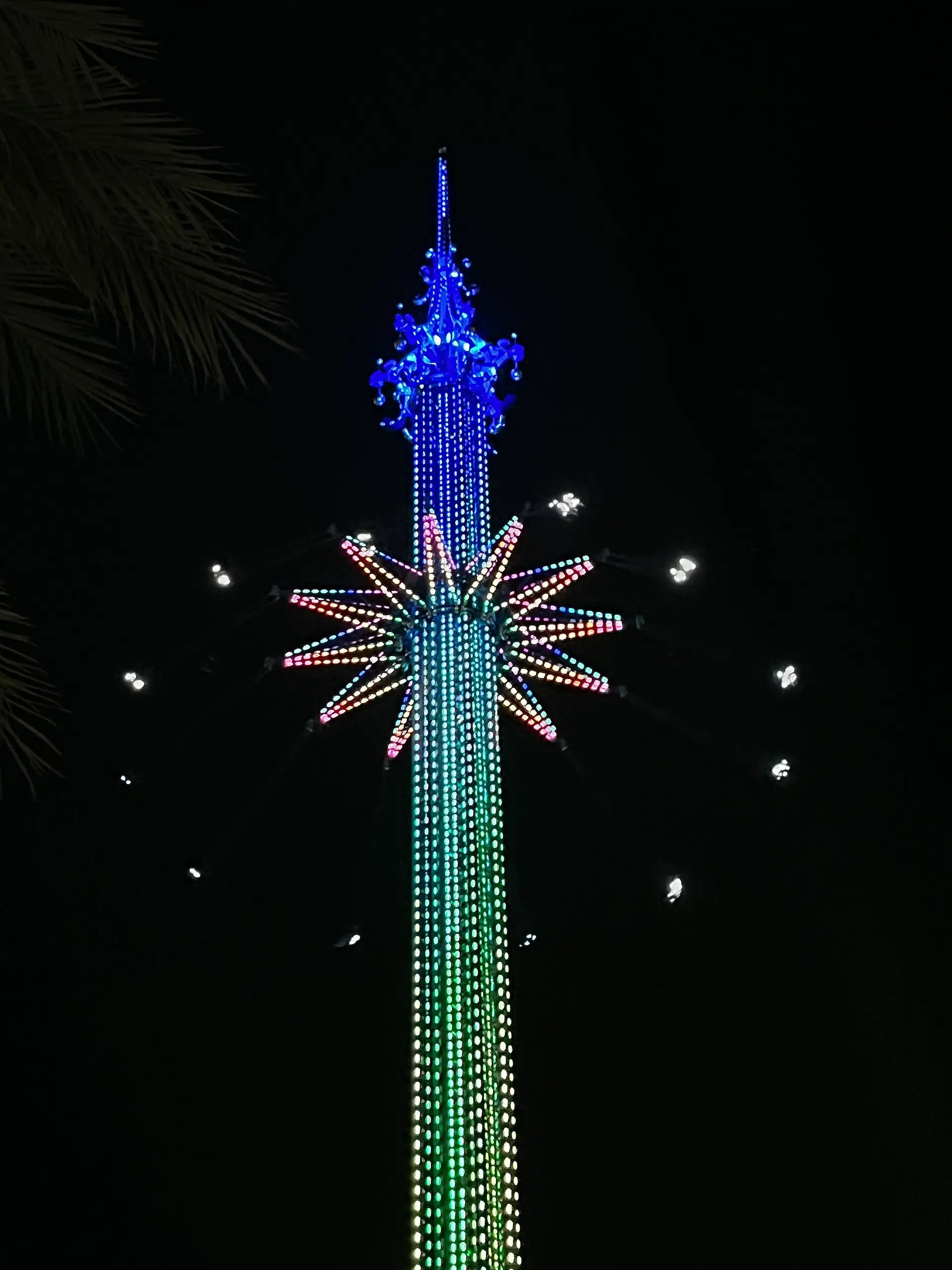 Der Orlando StarFlyer bei Nacht, die Schaukelarme beleuchtet und ausgeschwenkt über dem International Drive