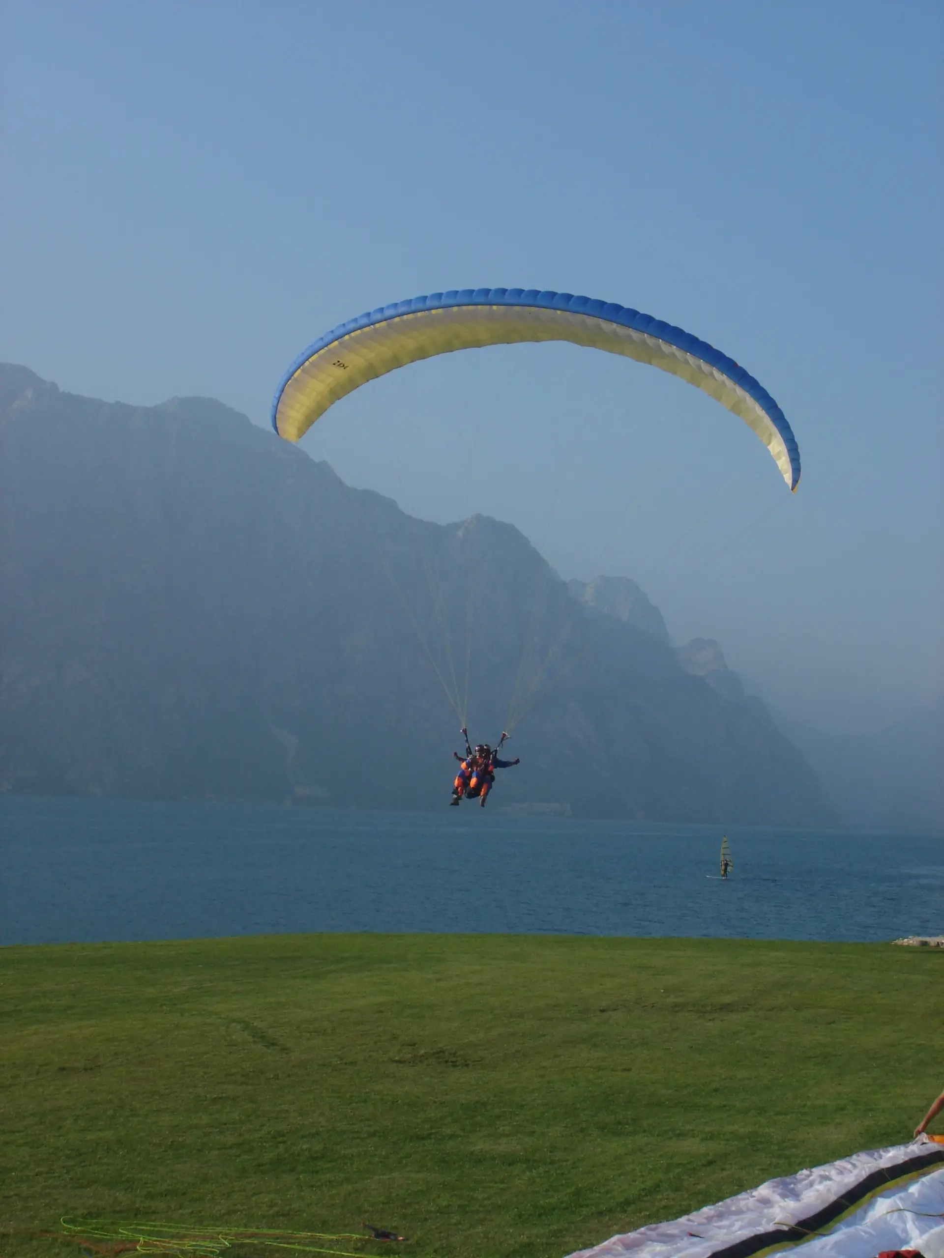 Ein Gleitschirm über dem Gardasee bei Malcesine, der See tief unten