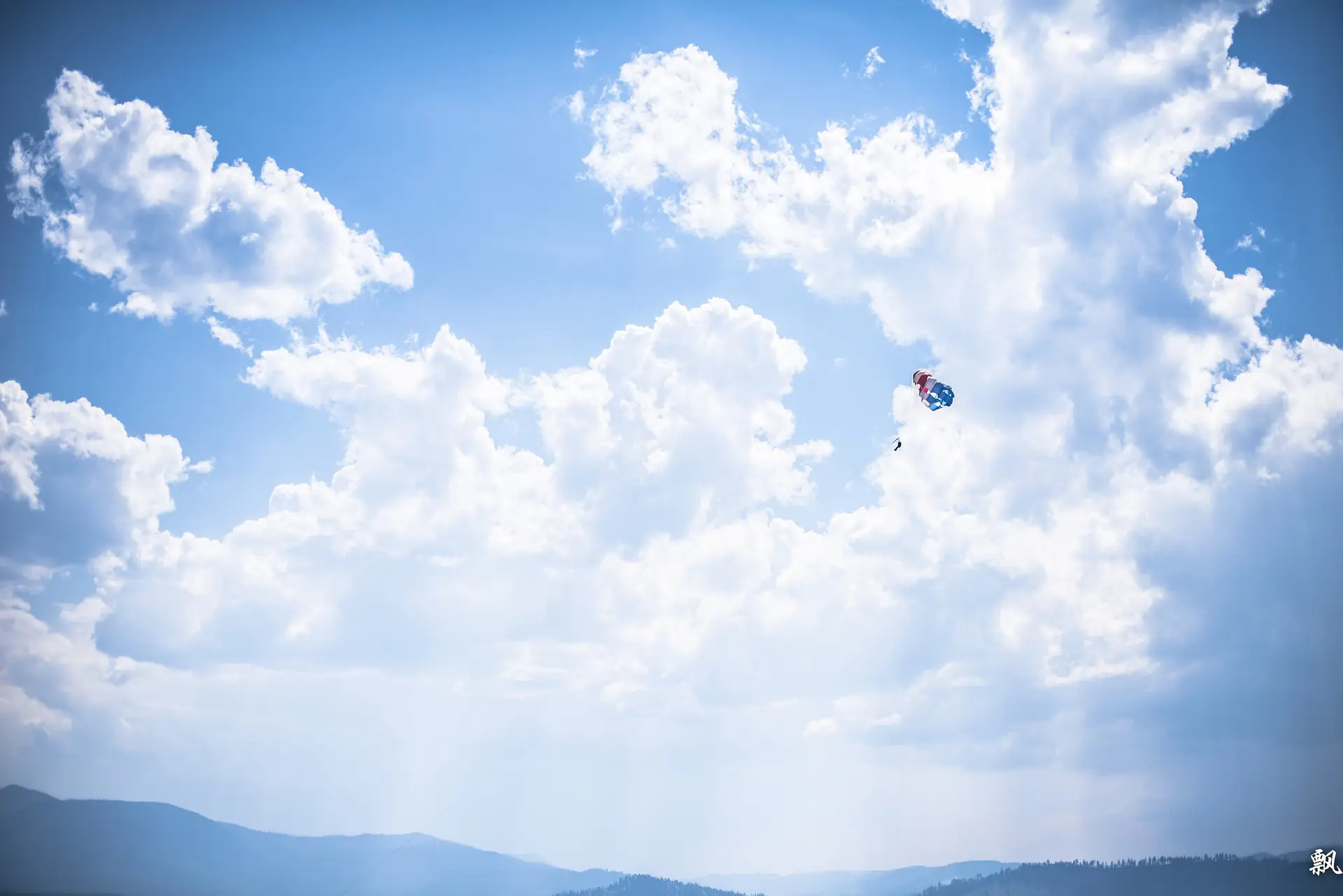 A parasail canopy over blue Lake Tahoe with snow-capped mountains behind