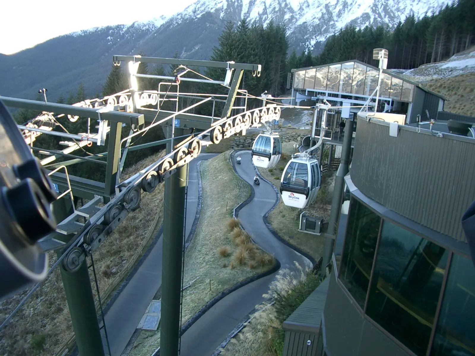 A rider in a helmet steering a Skyline luge cart down the concrete track on Bob's Peak above Queenstown