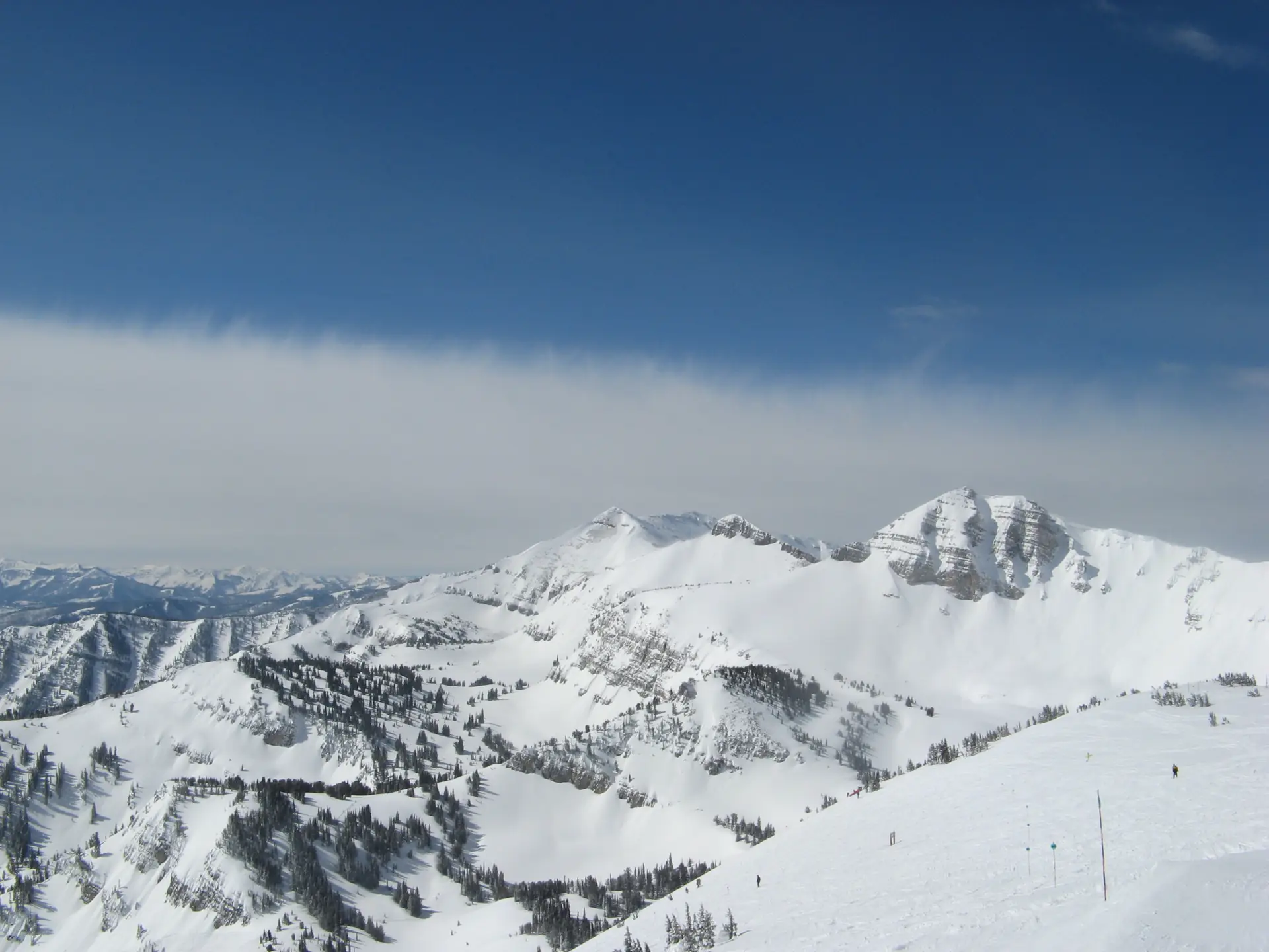 The view from the summit of Rendezvous Mountain over snow-covered ridges towards the valley
