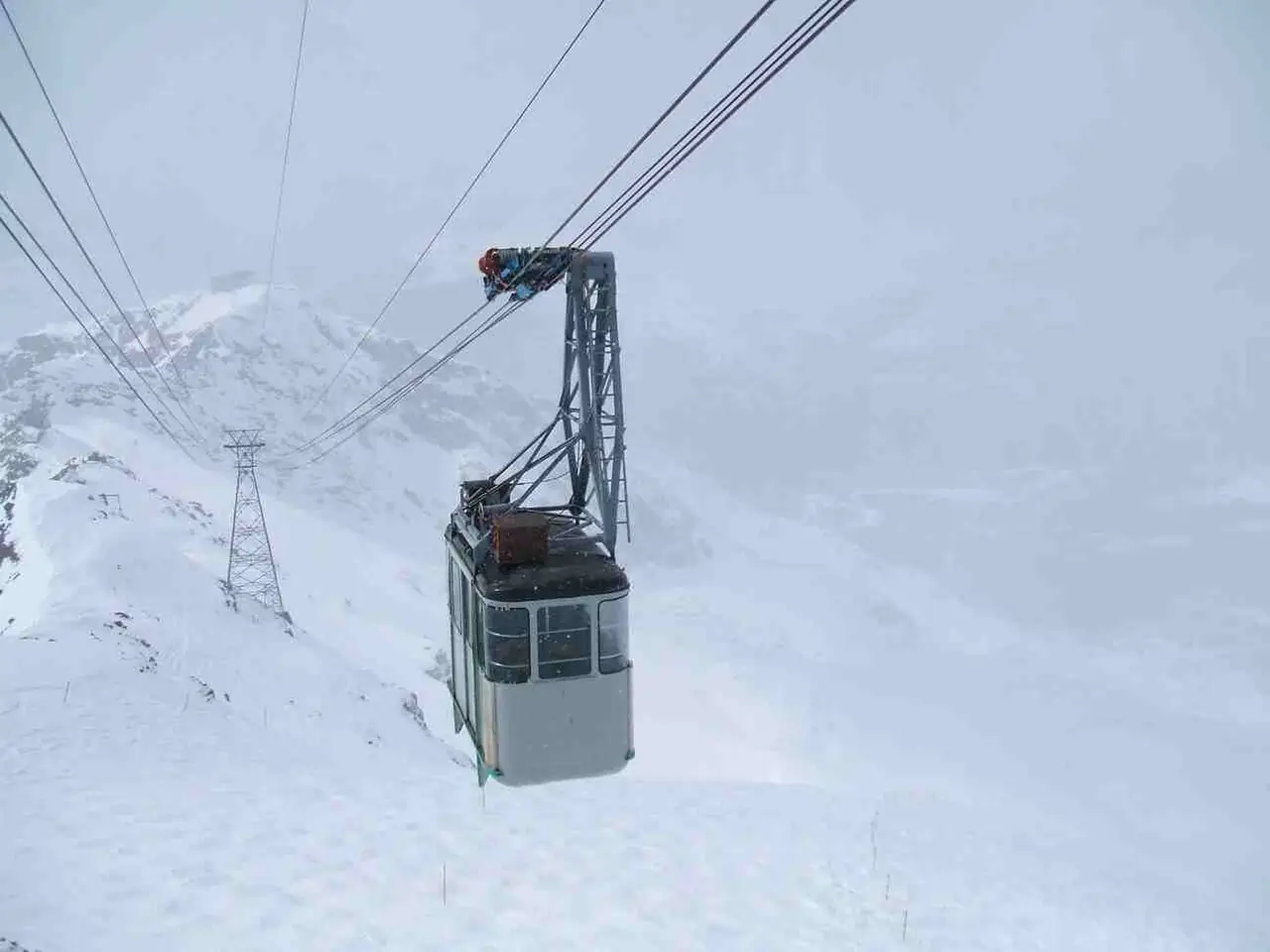 A Stockhorn cable car cabin rising above the alpine slopes with the mountain lake below
