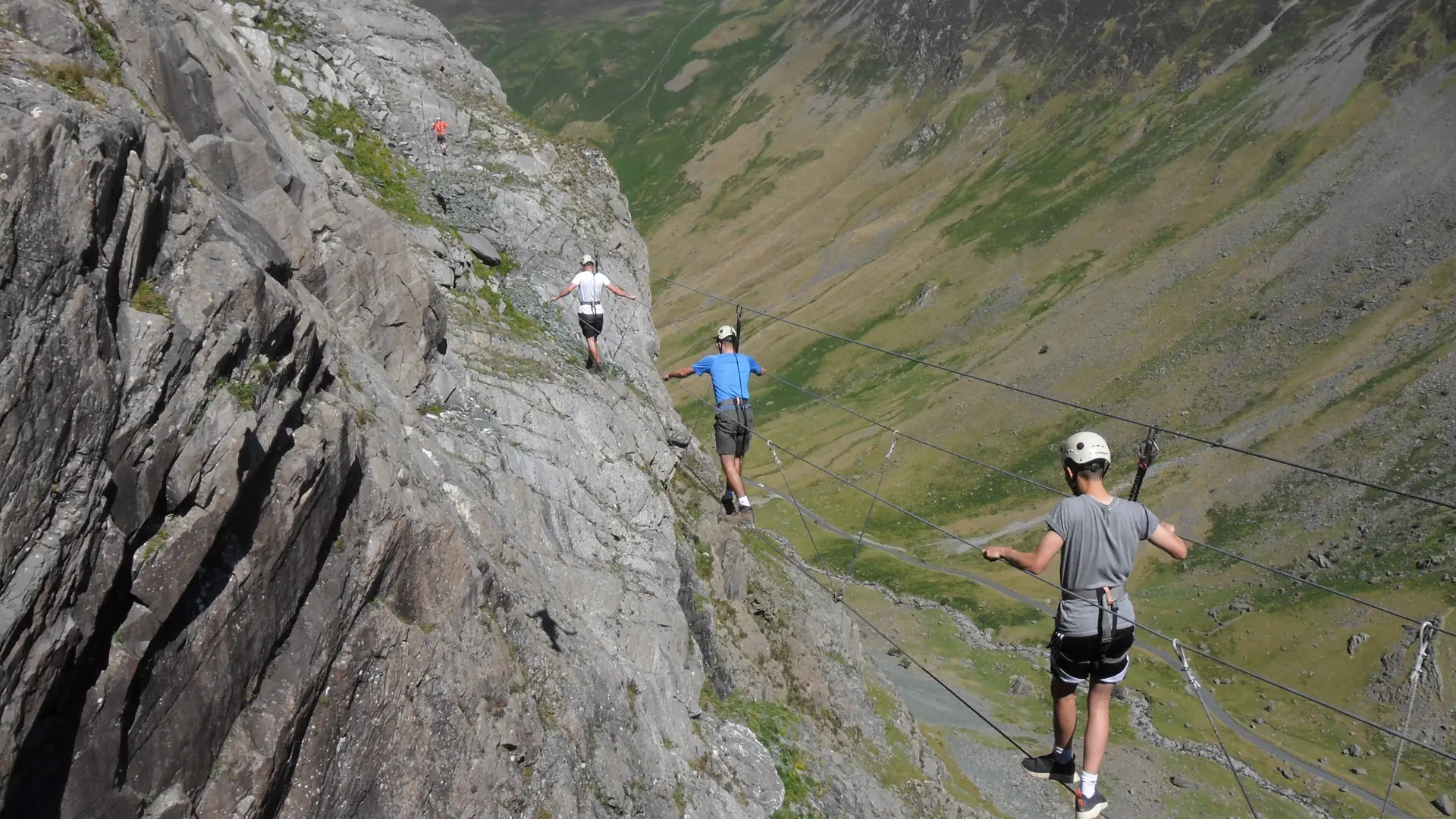 Klettersteiggeher auf der Burma Bridge am Honister über dem Tal