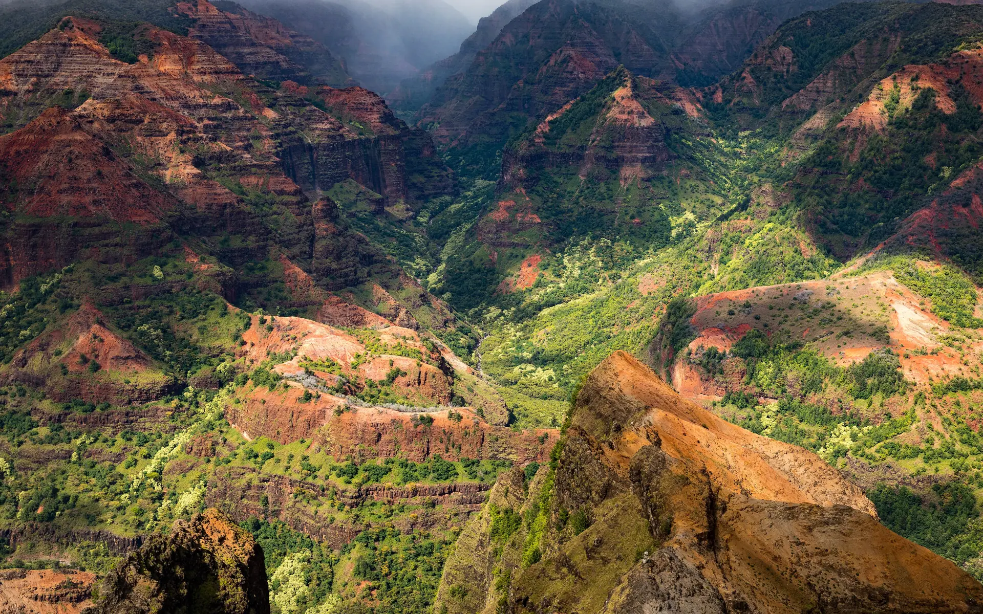 Der Waimea Canyon mit seinen rot und grün gestreiften Wänden unter Wolken