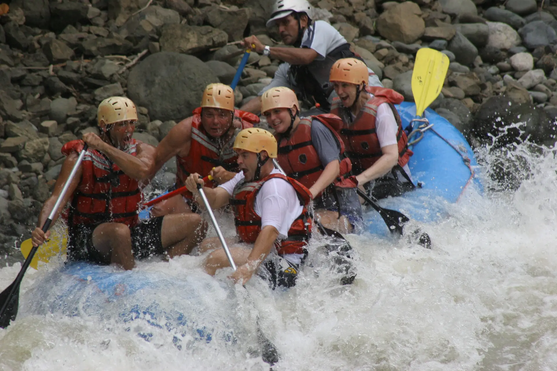 A raft crew paddling through whitewater on a Costa Rican river