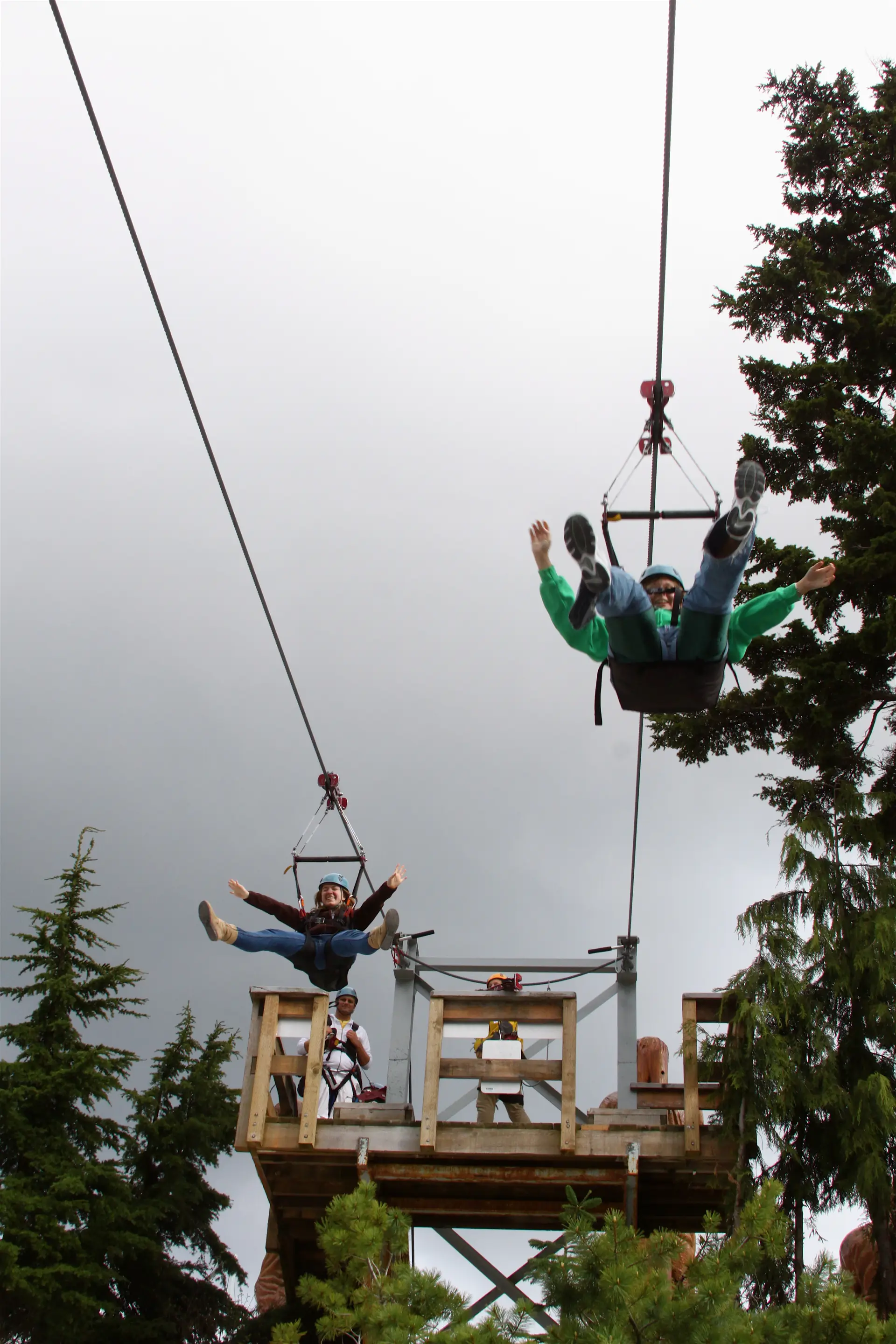 Zwei Fahrer starten nebeneinander von einer Zipline-Plattform am Grouse Mountain